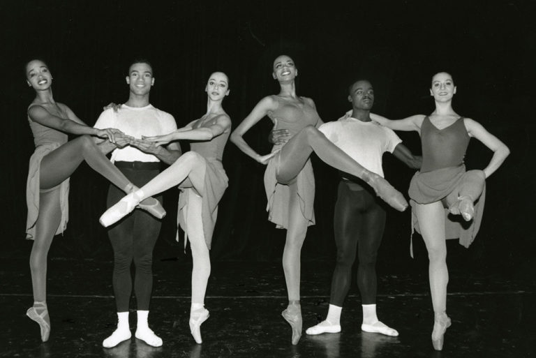 four femal and two male ballet dancers posing
